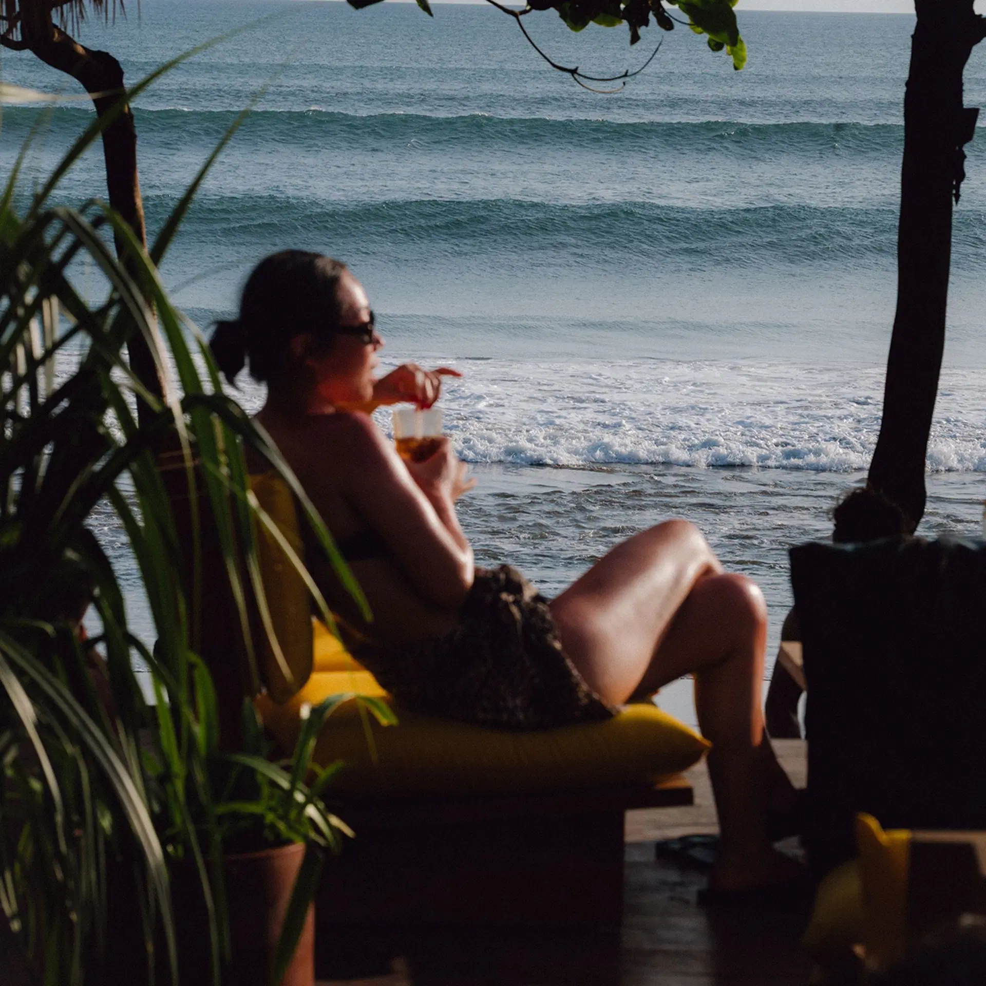 Guest relaxing beachside with a drink at Potato Head Beach Club